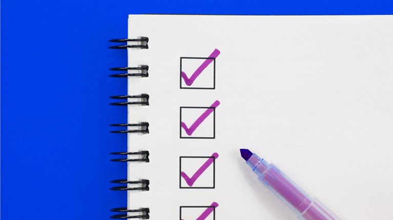 Close up of a notebook with checkboxes and a marker