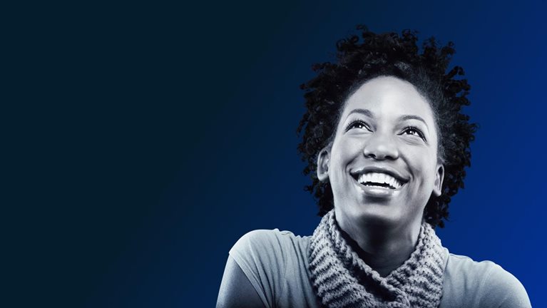 a Black woman smiling and looking upward