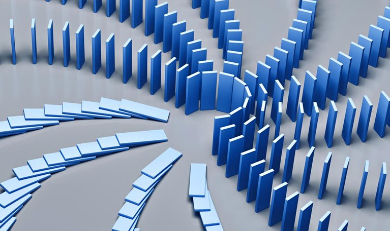 An array of dominoes cascading in a chain reaction on a blue backdrop