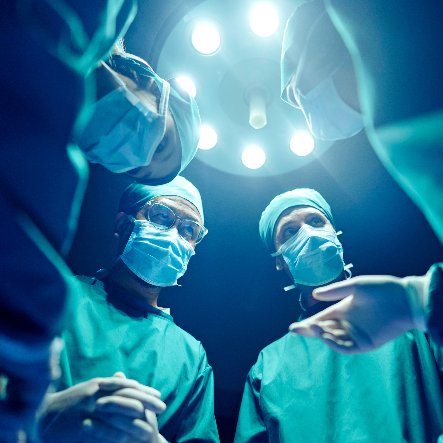 A group of surgeons wearing masks and performing surgery