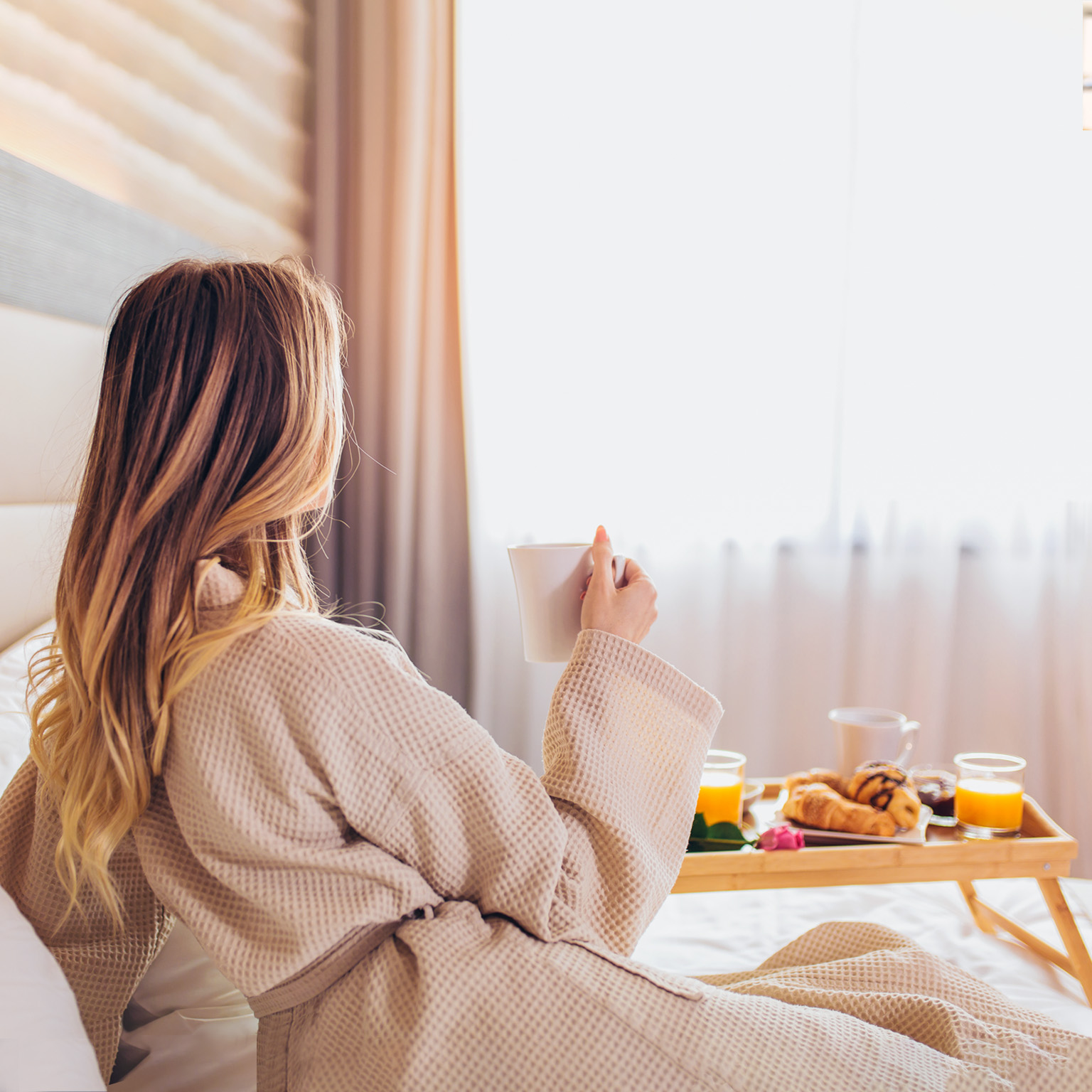 Woman laying and enjoying, breakfast in bed